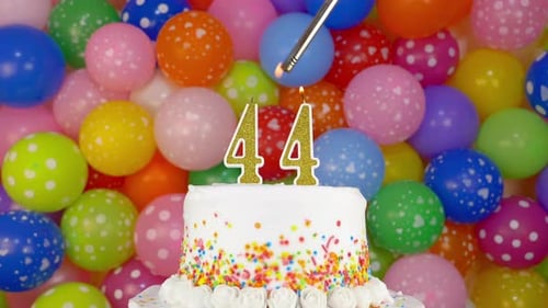 Person Light a Candles on the Celebration Cake