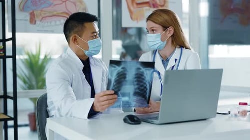 Doctors Discussing X-Ray Results in Bright Office