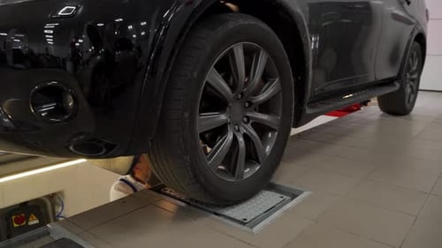 Auto Mechanic Inspects Vehicle Suspension and Steering Using Hydraulic Play Detector at Modern Car