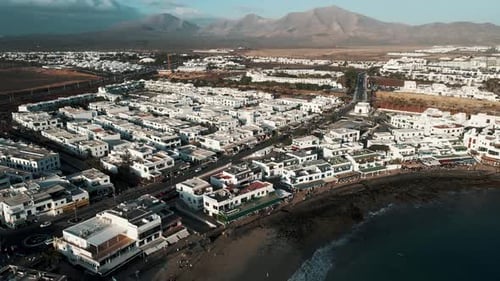 Aerial view of coastal town and ocean with mountains, Spain.
