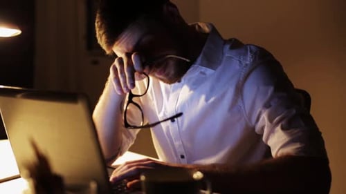 Man working on laptop late at night