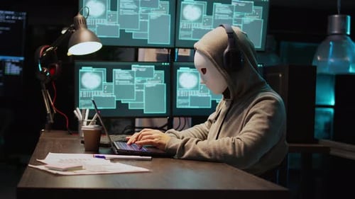 Joven ladrón de ordenadores con máscara hackeando un servidor de computadora por la noche