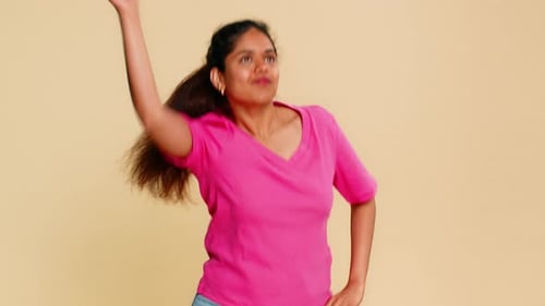 Woman with Ponytail Dancing in Front of Beige Backdrop