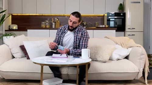 Man Doing Finances at Home on Couch