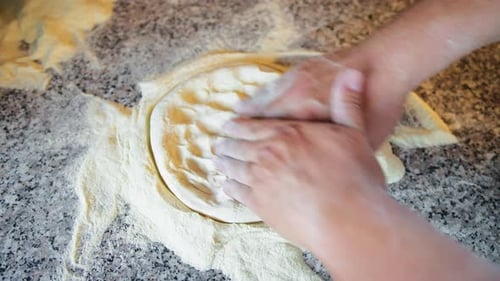 Sanfte Berührung des Küchenchefs über der rohen Pizza