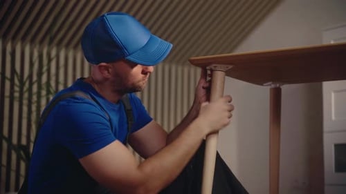 Expert Craftsman Repairs Wooden Table in Home Workshop with Detailed Attention to Structure
