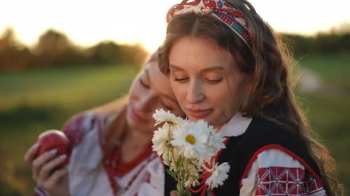 Two Women in Embroidered Dresses with Apple and Flowers