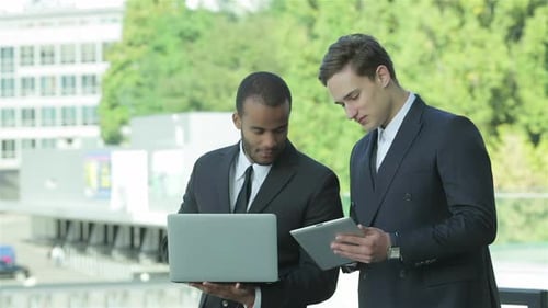 Businessmen Collaborate with Laptop and Tablet