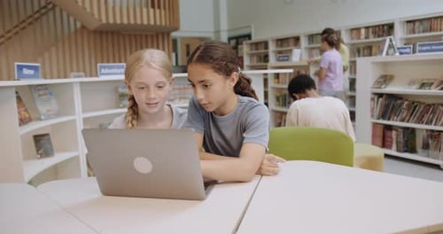 School Children Studying in Education Library using Laptop Technology