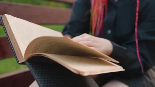 Leisurely Woman Engaging with Paperback Amidst Tranquil Park Surroundings Calm Woman with Neon Nails