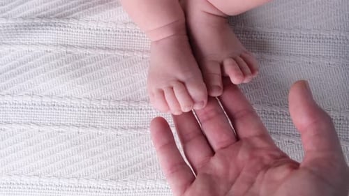 Sweet Newborn Feet Close Up with Gentle Touch