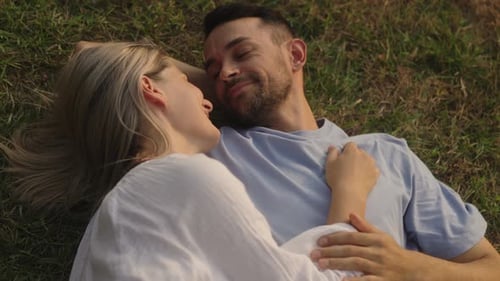 Romantic Couple Lying on Grass in Sunlight