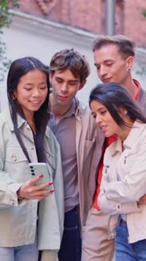 Young Adults Looking at Phone Outside