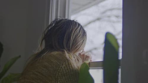 Woman Looking Out Window on Gray Day