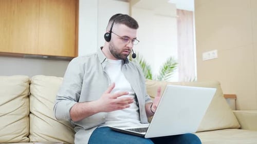 Man With Headset on Video Call From Home