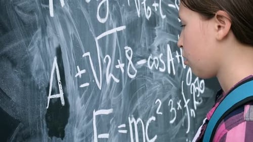 Young Girl Writing Math Equations on Chalkboard