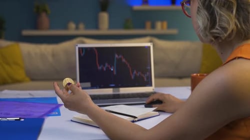 Woman Trading Bitcoin on Laptop at Home