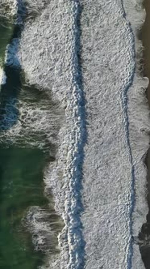 Vertical Video Aerial Turbulence Morning Storm's Waves Break a Wooden Pier Into Foamy Whiteness
