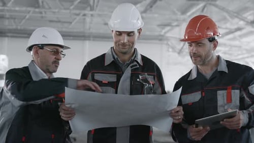 Ingenieurplan der Fertigungsarbeiten. Kaukasier mit Schutzhelm oder Schutzhelm