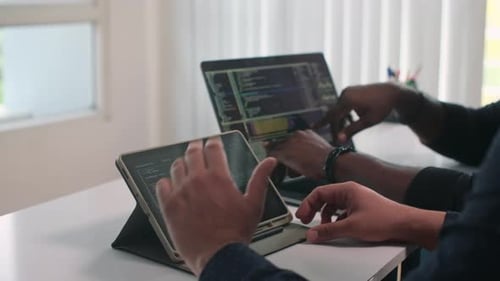Two Programmers Coding Together in an Office