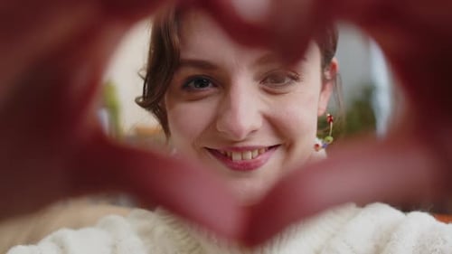 Smiling Woman Makes Heart Shape With Hands