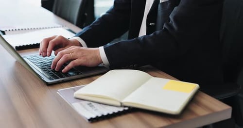 Бизнесмен, работающий руками и печатающий на ноутбуке или книге для общения, электронной почты или заметок в офисе