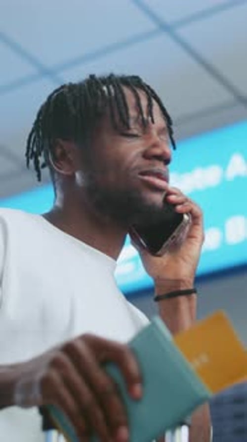 Airport Terminal Man Talking By Phone Checking Flight Information on Arrival and Departure Display