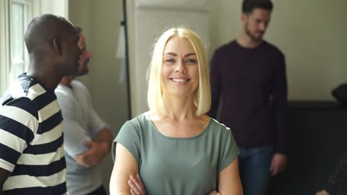 Confident young businesswoman smiling after a meeting at the office with colleagues