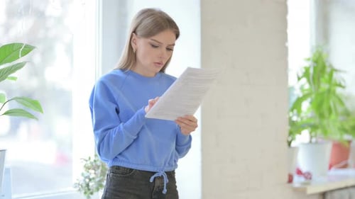 Woman Reading Documents in a Bright Room