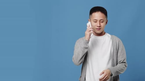 Young Man Receiving a Phone Call and Smiling