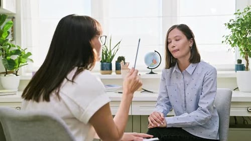 Two Women Talking in a Bright Office Environment