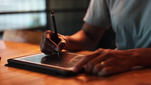 Stylus and Tablet Used at Wooden Table