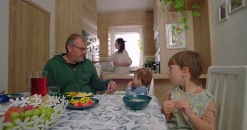 Family at Table Eating Breakfast in Bright Home