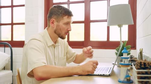 Man Working on Laptop at Home During the Day
