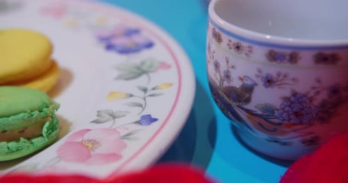 Macarons on Plate with Cup of Tea and Roses
