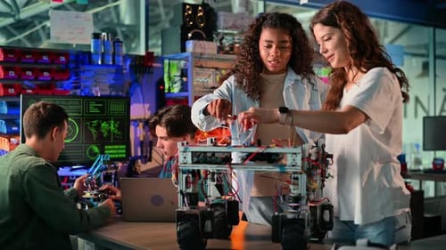 Group of young people doing experiments in robotics in a laboratory. Robot and tools on the table