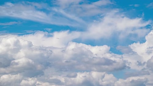 Beautiful summer day sky with fluffy white clouds time lapse in bright blue atmosphere.