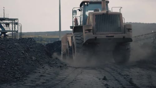 Vor der krassen Kulisse der Mine wirft ein Frontlader beim Wegfahren einen furchtbaren Schatten, s