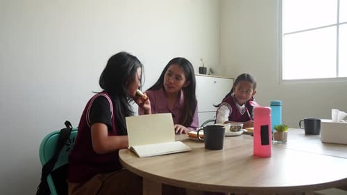 Woman and Girls Eating Breakfast at Home