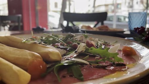 Restaurant appetizer with jamon and breadsticks