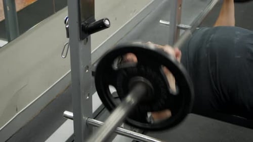 Man Doing Bench Press at the Gym