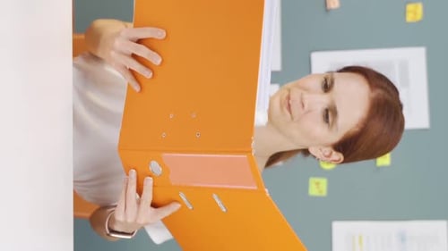 Woman With Binder Looking Stressed at Work