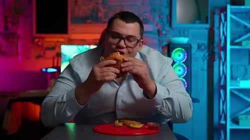 Man with Glasses Enjoys a Hamburger at Night