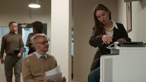 Female Office Worker and Colleague in Wheelchair Copying Documents on Scanner