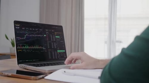 Young Financial Analyst Professional Using Laptop Application for Crypto Trading on Stock Market