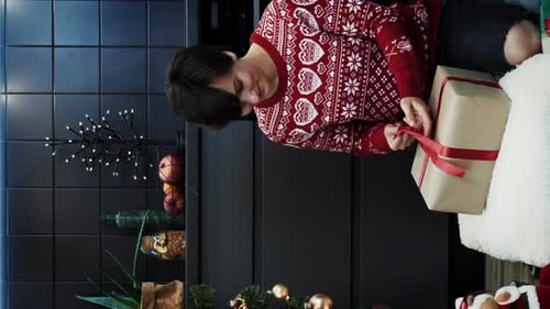 Tying Red Bow on Christmas Gift