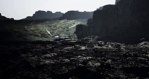 Mysterious Rocky Landscape with Shadowed Cliffs and Illuminated Terrain