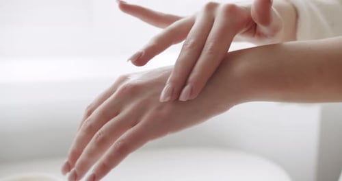 Woman Applying Hand Lotion for Skincare and Wellness