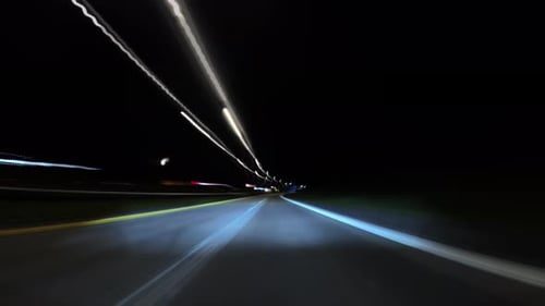 Des traînées lumineuses au milieu d'un hyperlapsus nocturne pendant la conduite