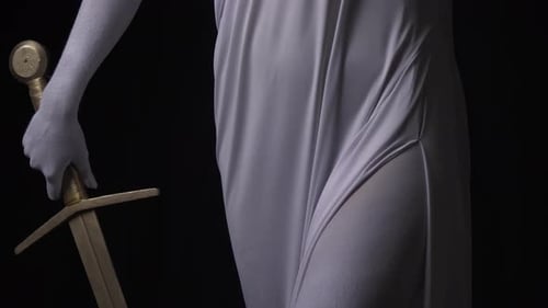 Close Up of the Hands of Themis Lifting Up the Golden Scales